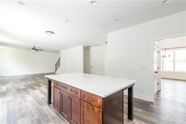 kitchen featuring a kitchen breakfast bar, hardwood / wood-style floors, a center island, and ceiling fan