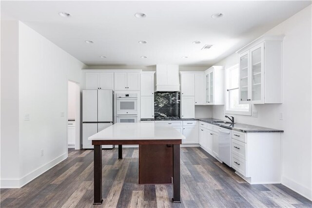 kitchen featuring white appliances, dark hardwood / wood-style floors, sink, and white cabinets