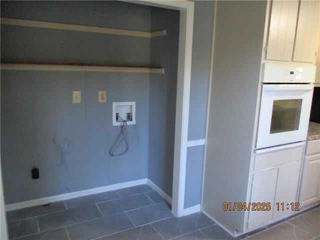 laundry room with hookup for a washing machine and dark tile patterned flooring