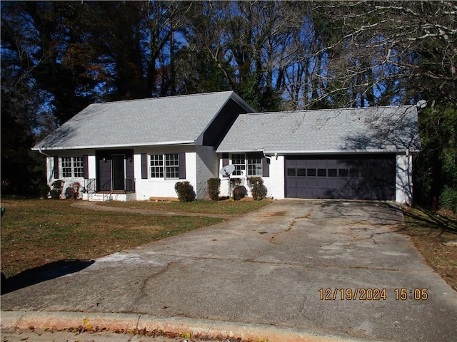 ranch-style house featuring a front yard and a garage