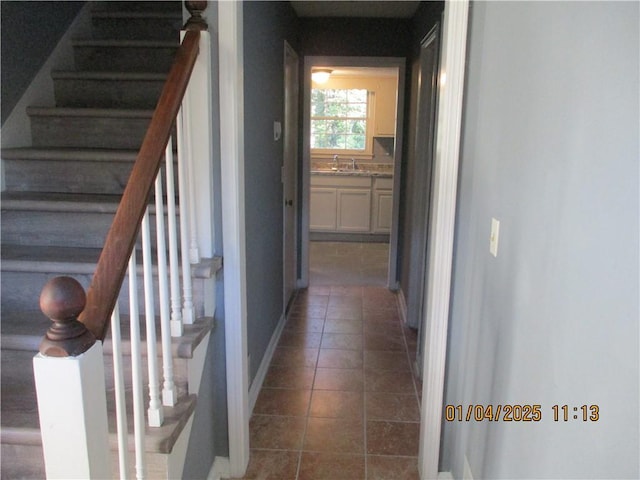 corridor with dark tile patterned floors and sink