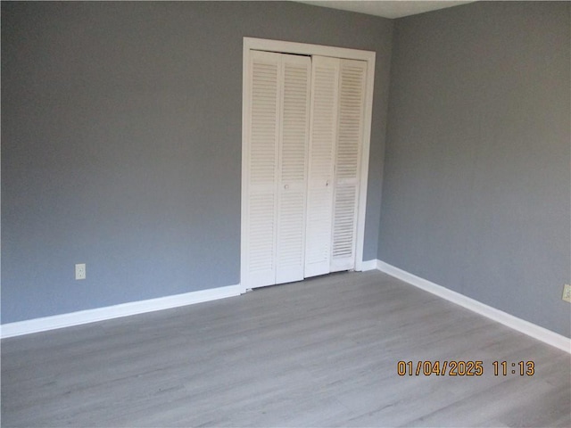 unfurnished bedroom with wood-type flooring and a closet