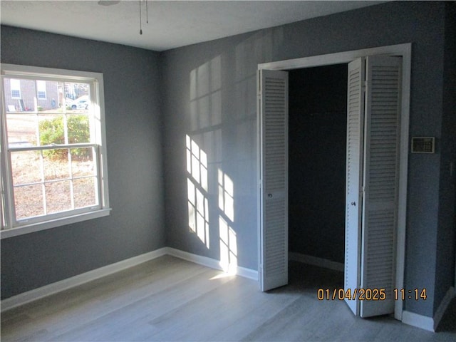 unfurnished bedroom with light wood-type flooring and a closet