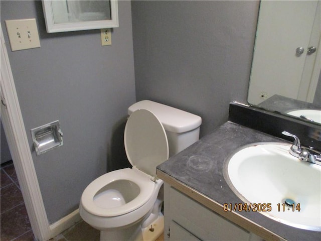 bathroom with tile patterned flooring, vanity, and toilet