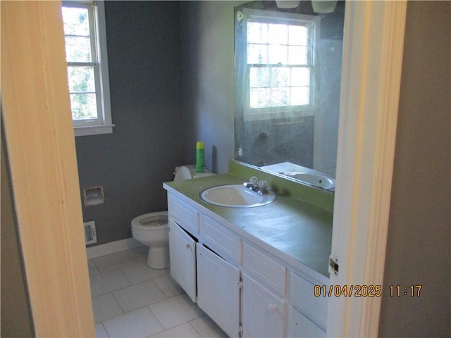 bathroom with tile patterned floors, plenty of natural light, vanity, and toilet