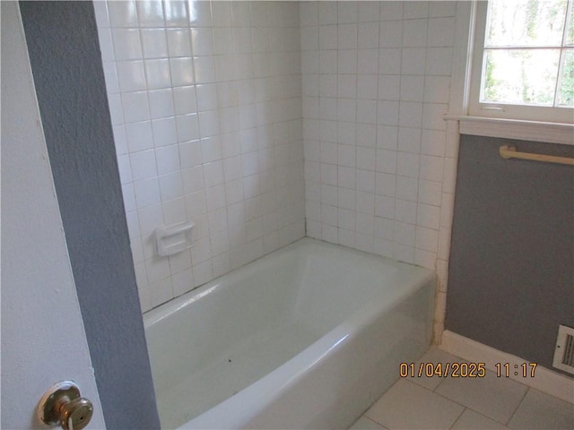 bathroom featuring tile patterned floors and tiled shower / bath