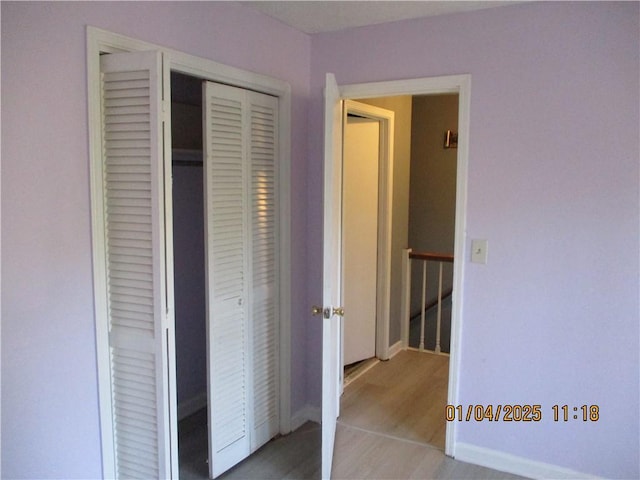 unfurnished bedroom featuring light hardwood / wood-style flooring and a closet