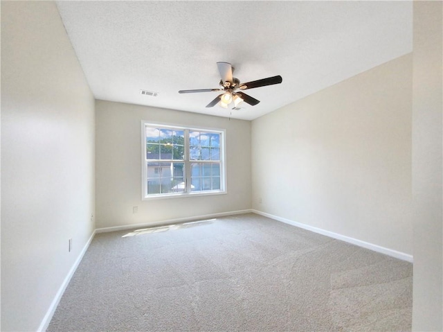 carpeted spare room featuring ceiling fan and a textured ceiling