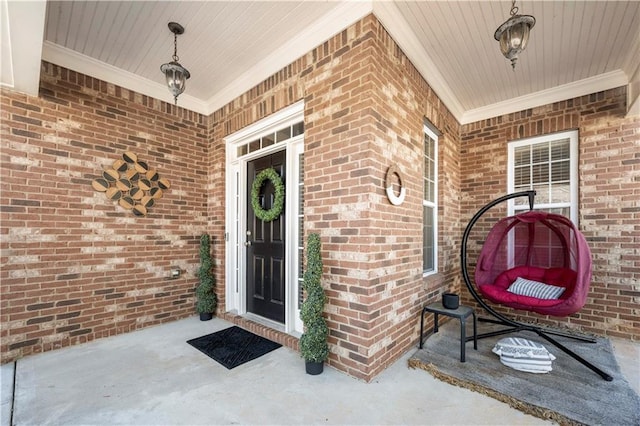 entrance to property with a porch and brick siding