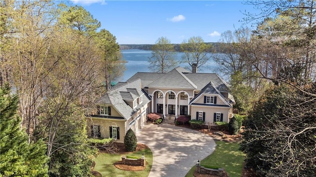 1070 Prosperity Pt, Greensboro, GA 30642 - view of front of house with driveway, a chimney, stucco siding, a water view, and a garage