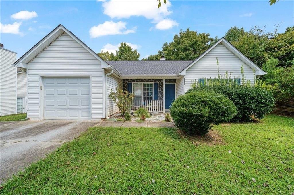 ranch-style house featuring a garage, a front yard, and a porch