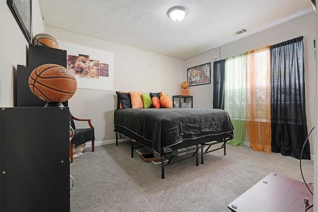 bedroom featuring light colored carpet and a textured ceiling