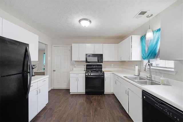 kitchen featuring sink, white cabinetry, hanging light fixtures, black appliances, and dark hardwood / wood-style flooring