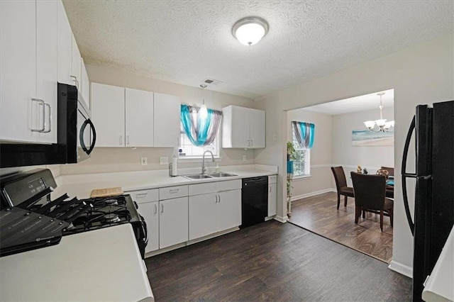 kitchen featuring white cabinets, sink, hanging light fixtures, and black appliances