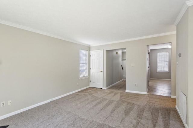 tiled empty room featuring carpet floors, baseboards, visible vents, and crown molding