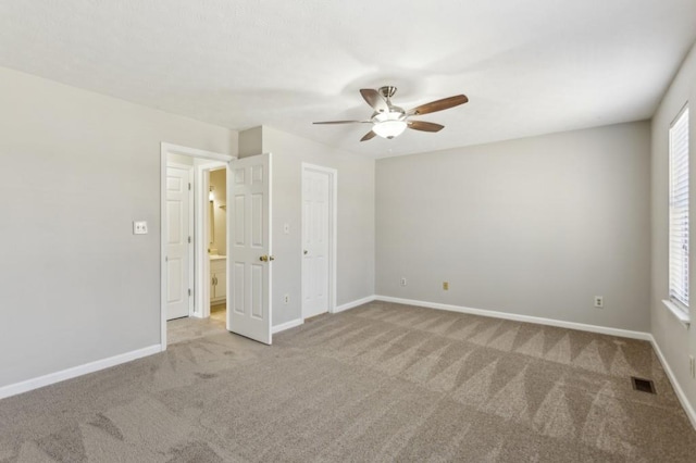 spare room featuring baseboards, visible vents, ceiling fan, and carpet flooring