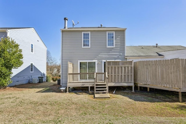 back of property with central AC, fence, a deck, and a lawn