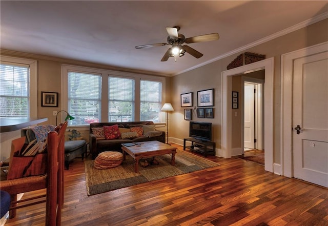 living room with ceiling fan, crown molding, dark wood-type flooring, and a healthy amount of sunlight