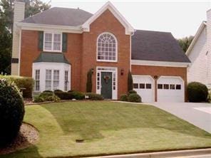 1414 Justin Dr, Lawrenceville, GA 30043 - colonial inspired home with a chimney, driveway, a front lawn, and a garage