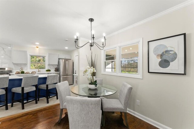 dining area featuring ornamental molding, dark hardwood / wood-style floors, and a notable chandelier