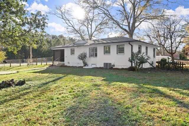 back of property with a sunroom, cooling unit, and a yard