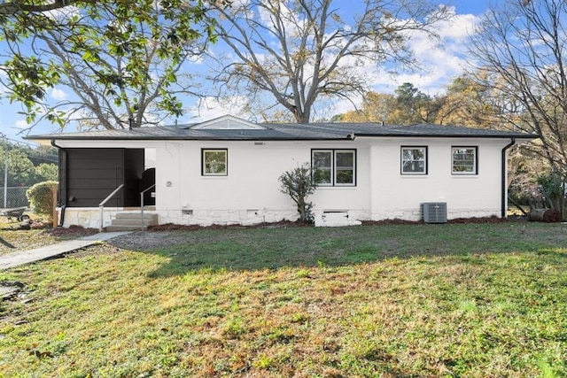 back of property with a lawn and central AC