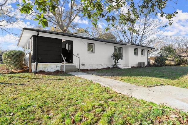 ranch-style house with a front lawn and central AC unit