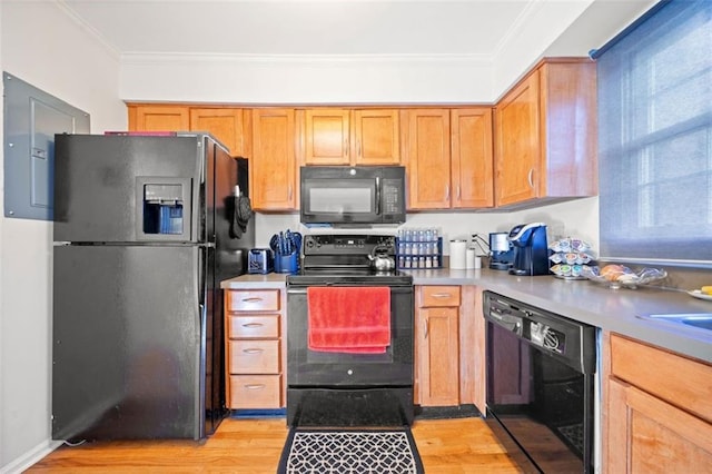 kitchen featuring light wood-style flooring, black appliances, light countertops, and ornamental molding