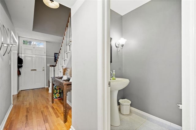 bathroom with a sink, baseboards, and wood finished floors