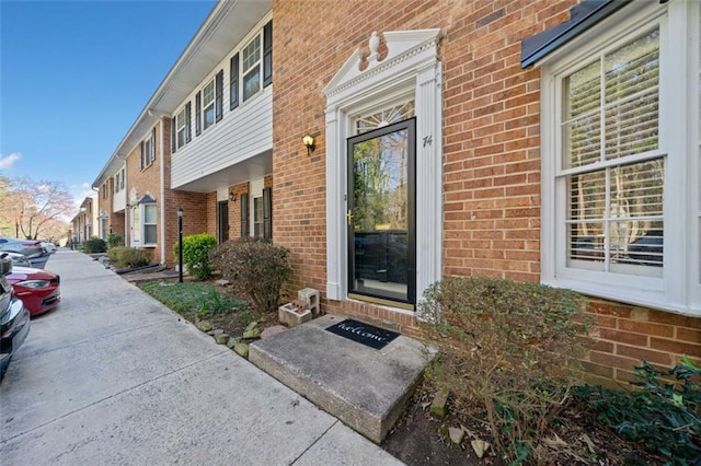 entrance to property featuring brick siding