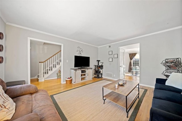 living room with visible vents, wood finished floors, and stairway