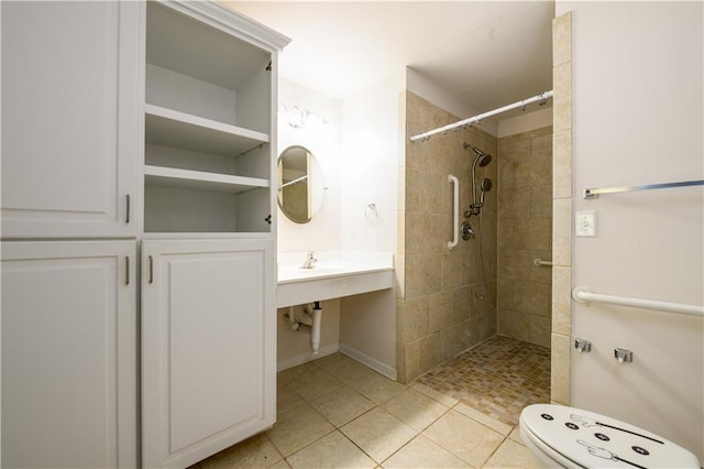 full bathroom featuring toilet, a tile shower, and tile patterned floors