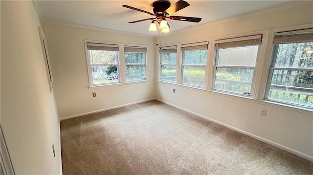 empty room with baseboards, crown molding, and light colored carpet