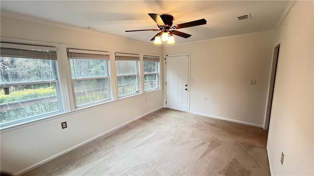 unfurnished room featuring baseboards, ornamental molding, visible vents, and light colored carpet