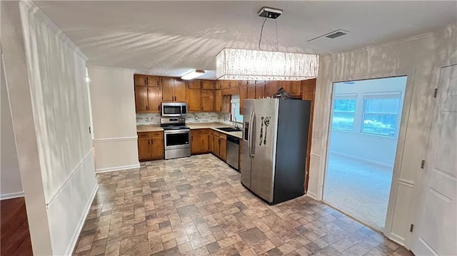 kitchen featuring stainless steel appliances, light countertops, visible vents, brown cabinetry, and a sink