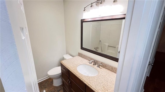 bathroom with toilet, baseboards, and vanity