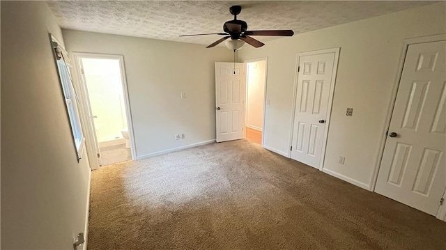 unfurnished bedroom with carpet, connected bathroom, a textured ceiling, and baseboards