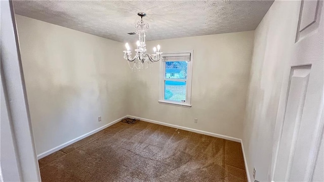 carpeted spare room with an inviting chandelier, baseboards, and a textured ceiling