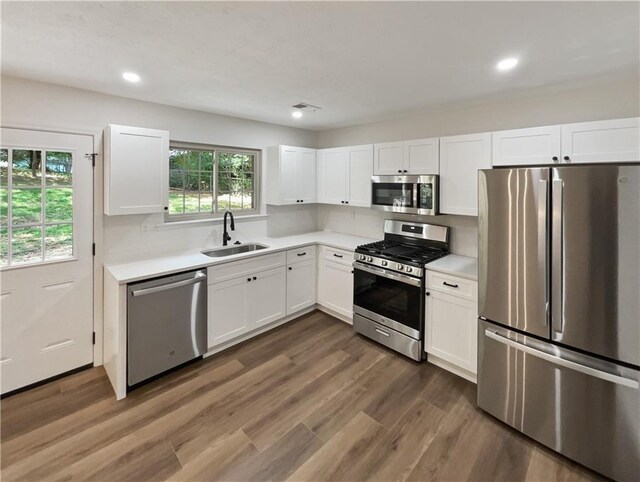 kitchen featuring white cabinetry, sink, stainless steel appliances, and dark hardwood / wood-style flooring