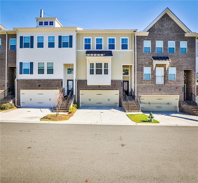 townhome / multi-family property featuring a garage, concrete driveway, and brick siding