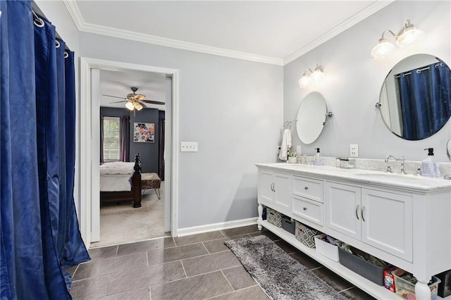 ensuite bathroom with double vanity, a ceiling fan, crown molding, a sink, and baseboards