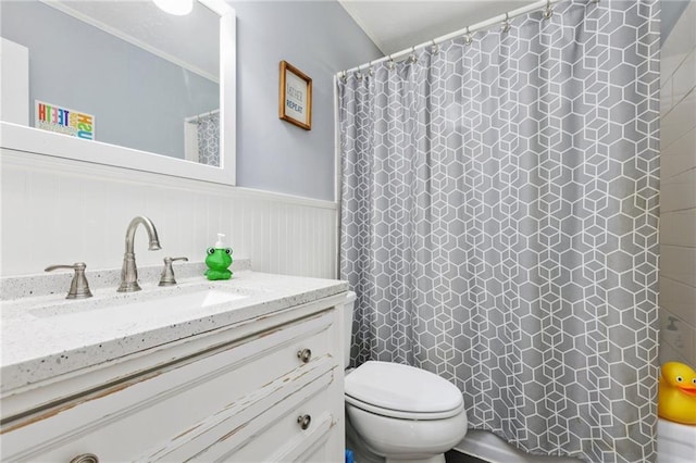 full bath with vanity, a wainscoted wall, toilet, and curtained shower