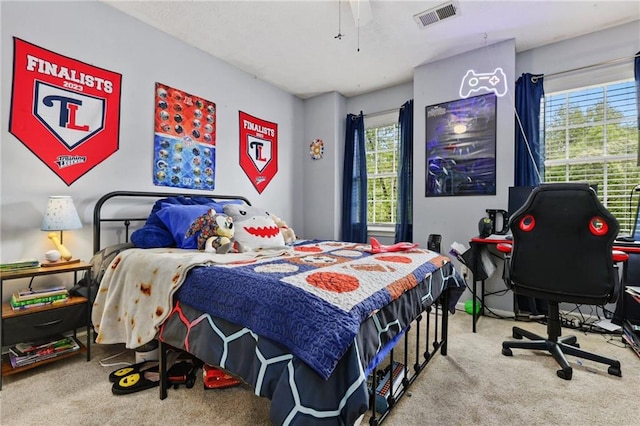 carpeted bedroom featuring visible vents