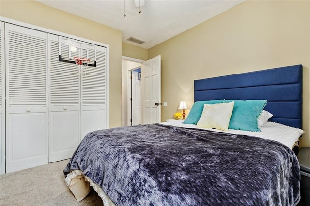 bedroom with visible vents, carpet, and a closet