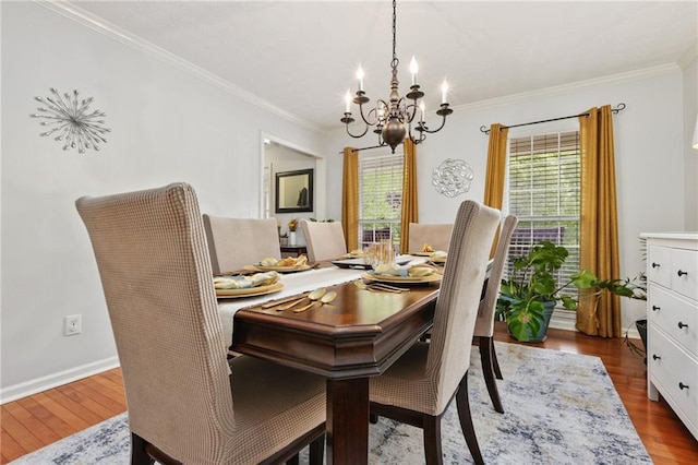 dining room featuring an inviting chandelier, ornamental molding, baseboards, and wood finished floors