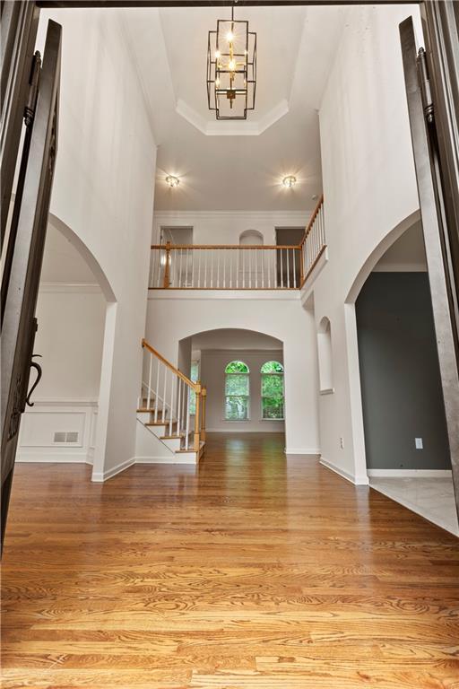 915 Summer Wind Pl, Roswell, GA 30075 - foyer with arched walkways, wood finished floors, stairway, a high ceiling, and a raised ceiling