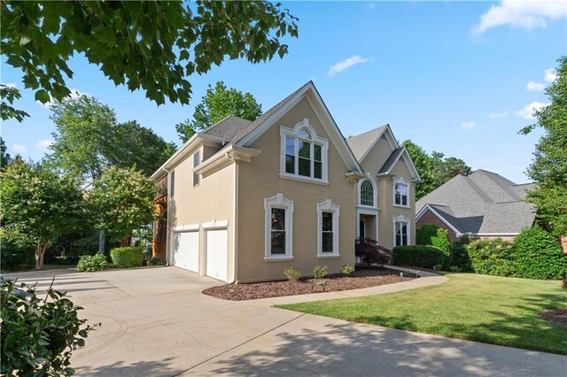 915 Summer Wind Pl, Roswell, GA 30075 - view of front of house with a garage, driveway, stucco siding, and a front lawn
