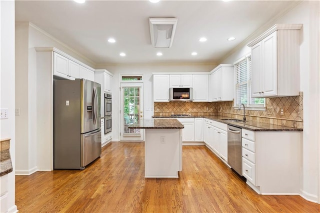 915 Summer Wind Pl, Roswell, GA 30075 - kitchen with appliances with stainless steel finishes, a center island, white cabinetry, dark stone counters, and light wood-type flooring