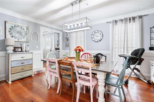 dining area with plenty of natural light, hardwood / wood-style floors, and ornamental molding