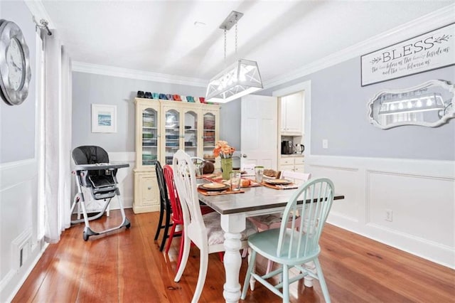 dining room featuring wood-type flooring and crown molding